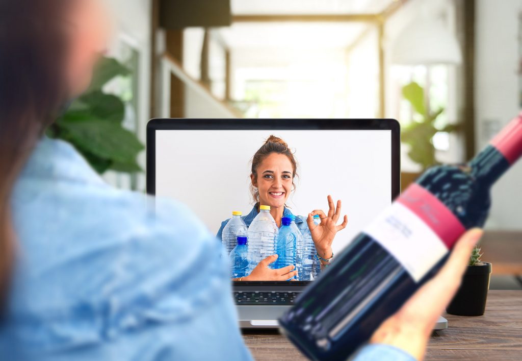 woman holding empty wine bottle, video call with friend holding empty plastic bottles