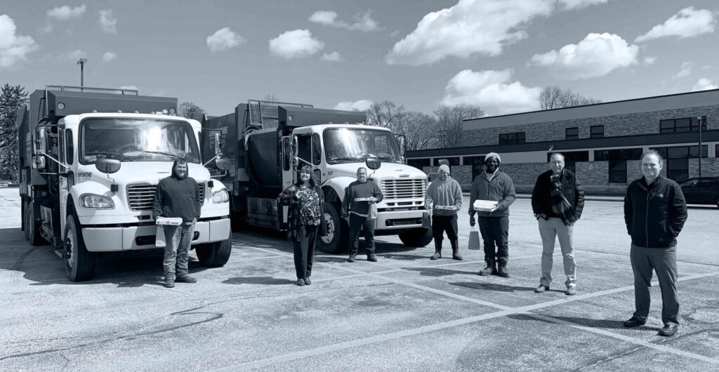 teammates standing in front of truck fleet