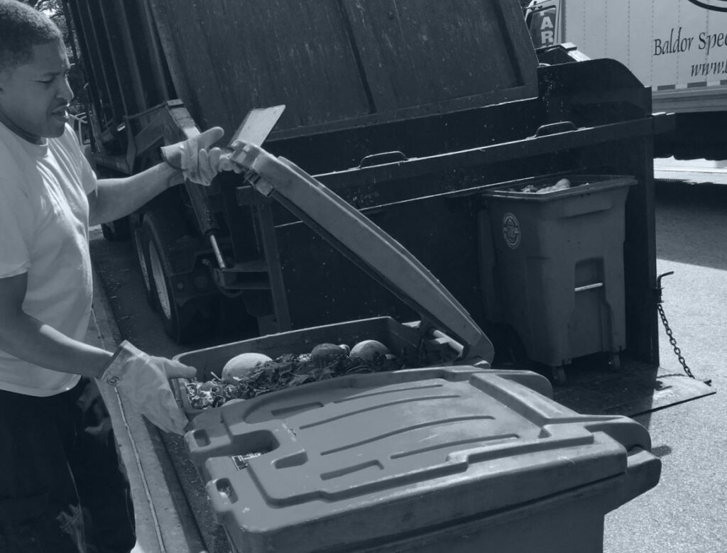 man closing waste bin filled with organic waste